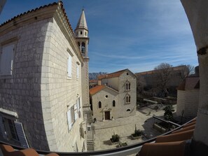 A stone building with a bell tower and a courtyard.
