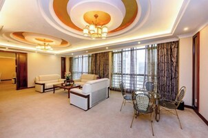 Un salón espacioso con un conjunto de sofás, una mesa de centro y un comedor con sillas.
