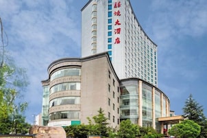 Un hotel moderno con fachada curva, varios pisos y ventanas amplias.