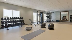 A gym with weightlifting equipment, dumbbells, a bench, and exercise balls. - Home2 Suites by Hilton Clovis (Clovis)