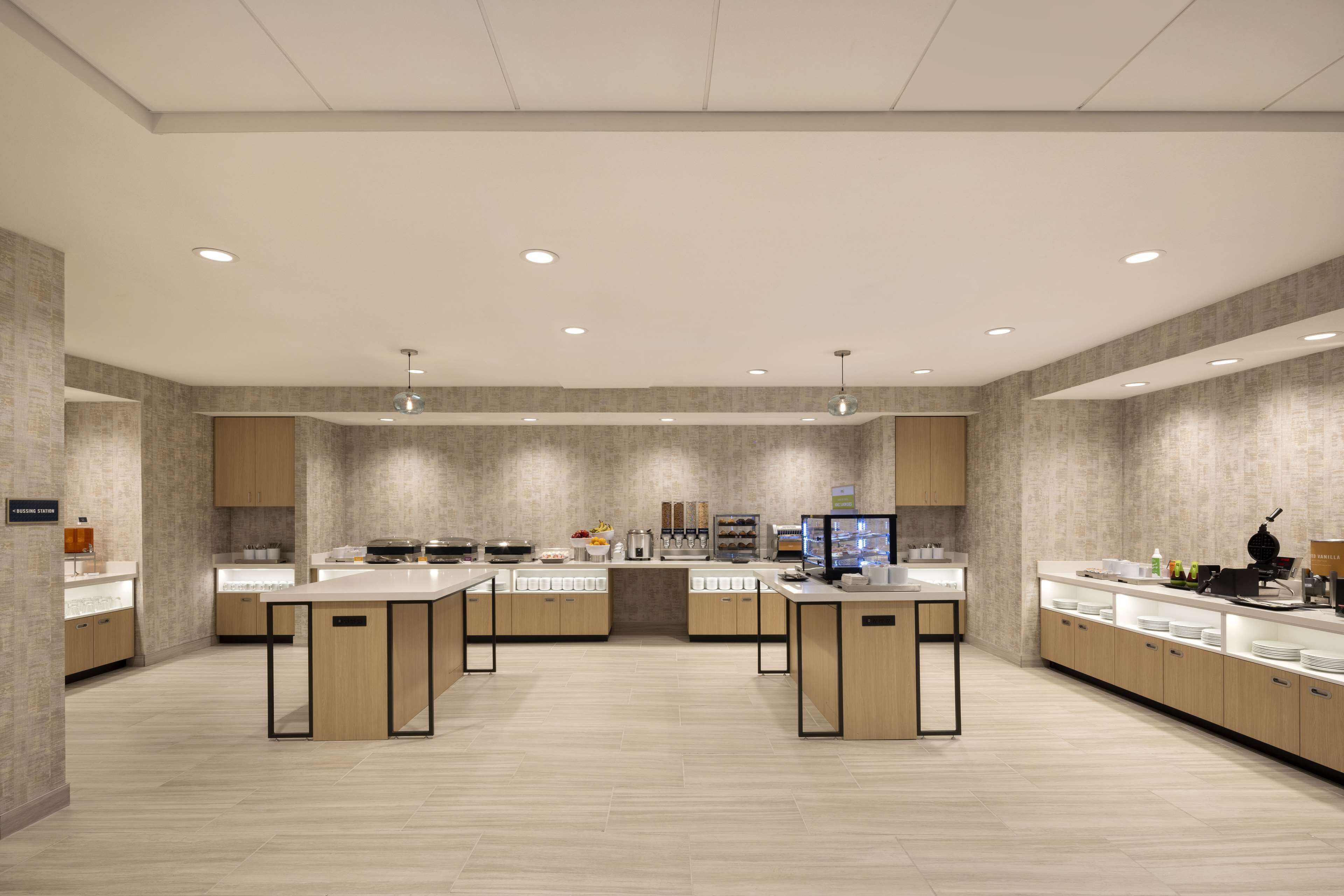 Een moderne keuken met een centraal eiland, houten kastjes en geïntegreerde apparatuur.