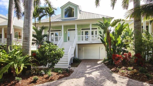 A two-story house with a covered porch and a garage. - All Seasons Villa (Captiva)