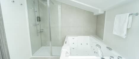 A modern bathroom with a glass-enclosed shower, a freestanding bathtub, and a towel rack on the wall.