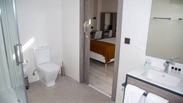 Un baño con inodoro, bidé y lavamanos.