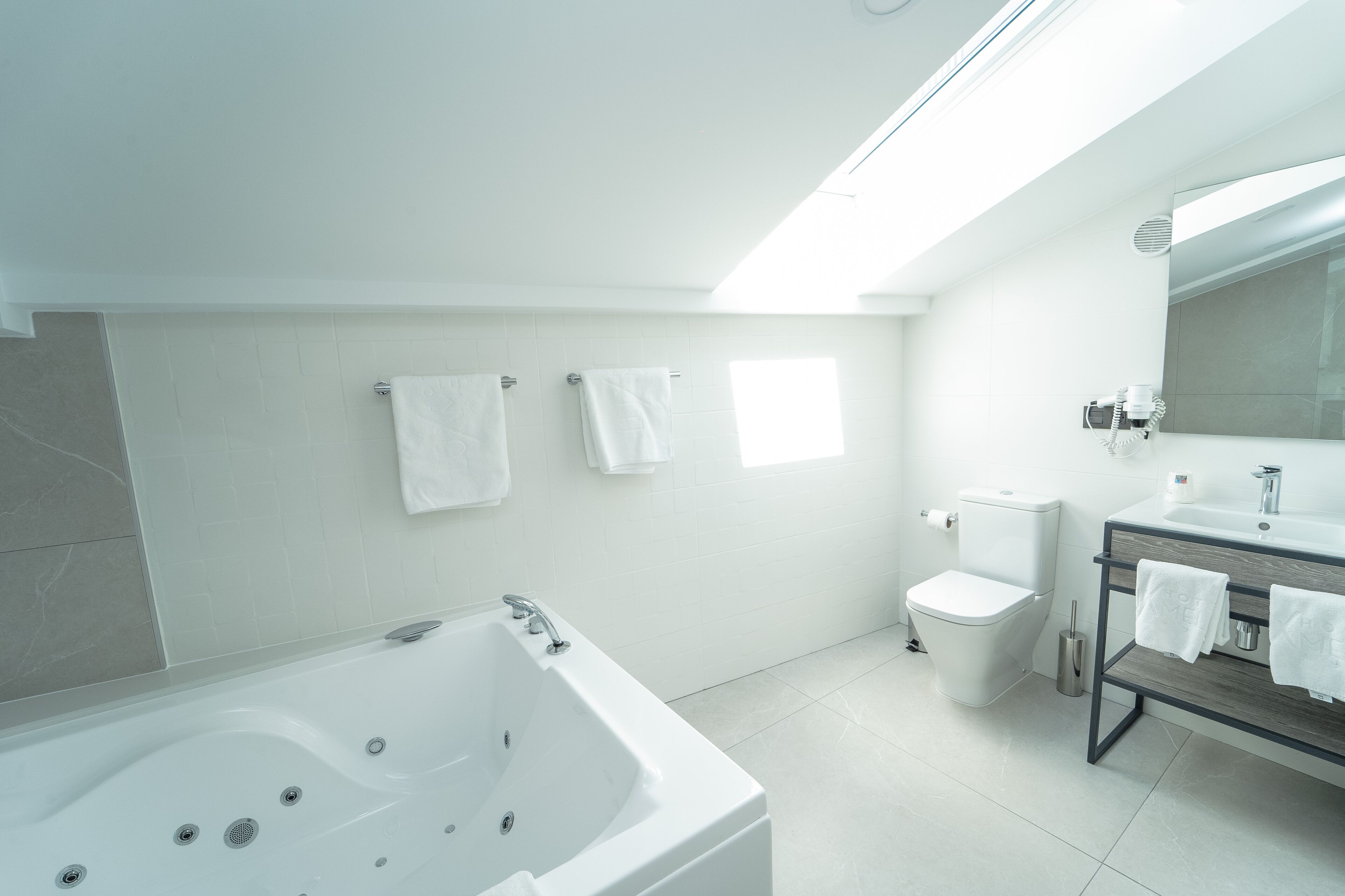 A modern bathroom with a bathtub, toilet, and sink.