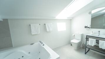 A modern bathroom with a bathtub, toilet, and sink.