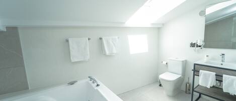 A modern bathroom with a bathtub, toilet, and sink.