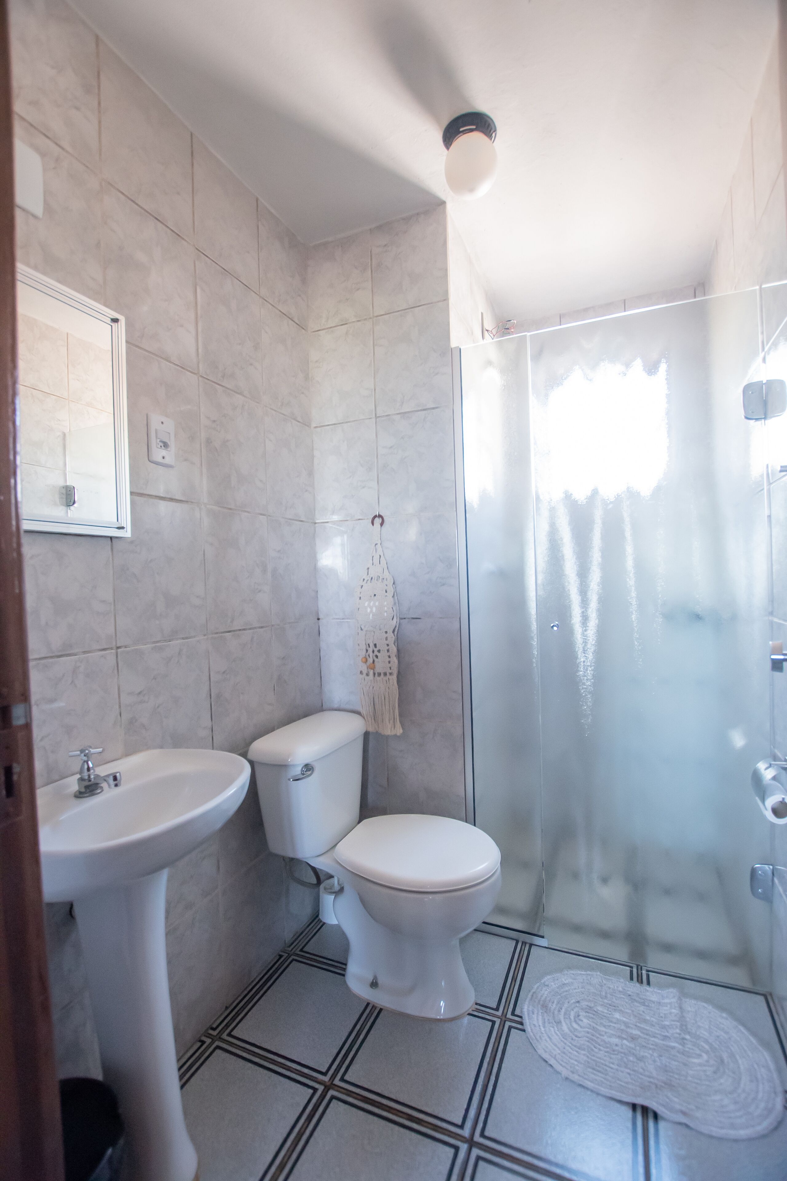A bathroom with a toilet, sink, and shower.