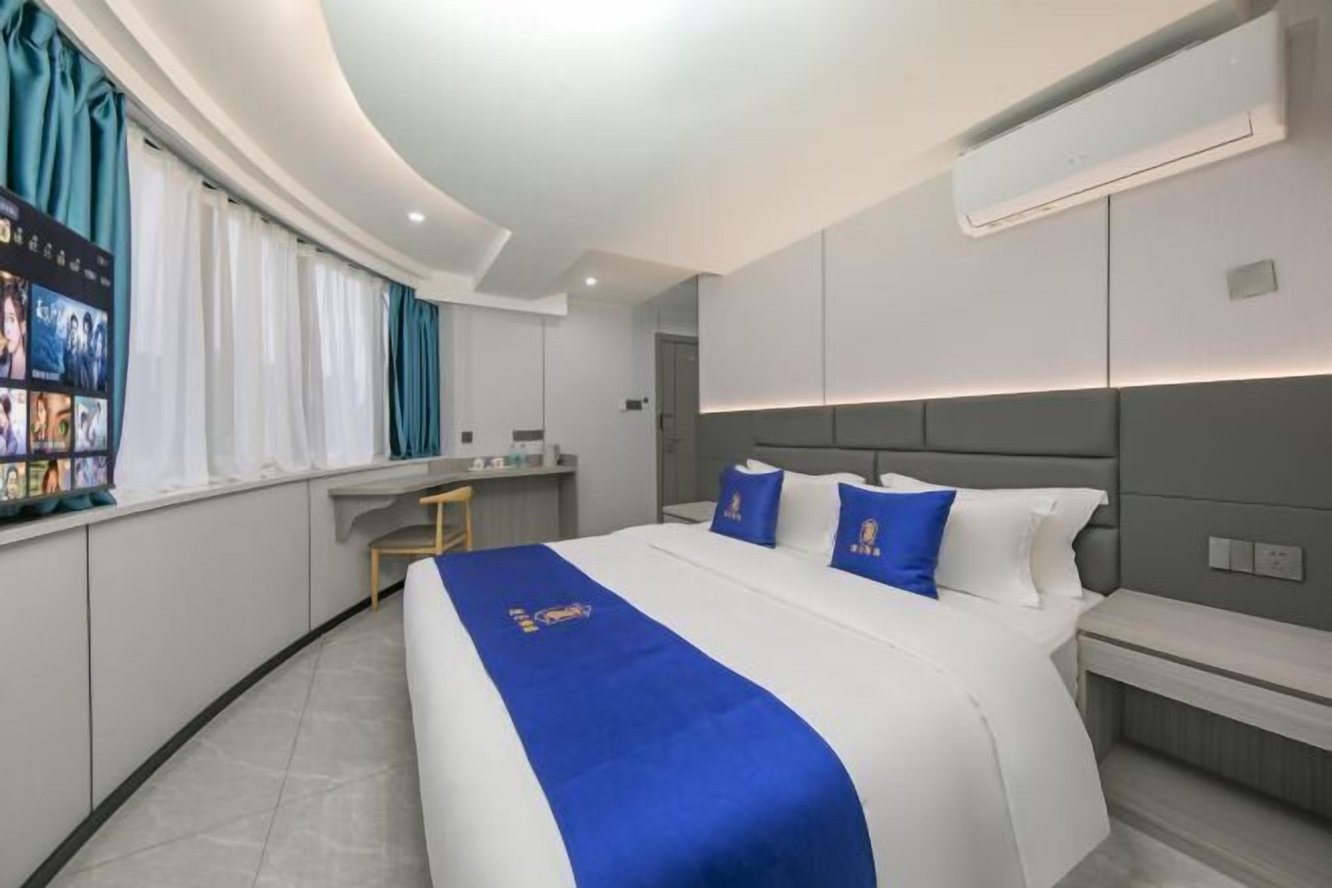 Quarto de hotel moderno com uma cama grande, uma escrivaninha e um espaço de estar.