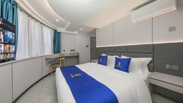 Quarto de hotel moderno com uma cama grande, uma escrivaninha e um espaço de estar.