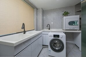 A compact laundry area with a washing machine, a sink, and a microwave. - Super 8 Selected Hotel (Fuzhou IKEA Shangyang Metro Station Branch) (Fuzhou)
