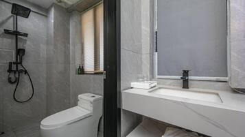 Un baño moderno con inodoro, ducha y lavamanos.