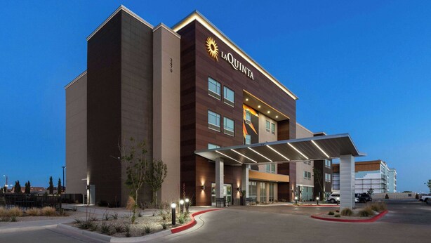 Ein La Quinta Hotel im modernen Design, mit einem markanten Eingang und einem überdachten Zugangsbereich.