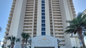A high-rise hotel with a central fountain, multiple balconies, and palm trees. - Stunning Beach Views of Gulf-14th Floor-Dog friendly-See the longest pier in FL! (Navarre)