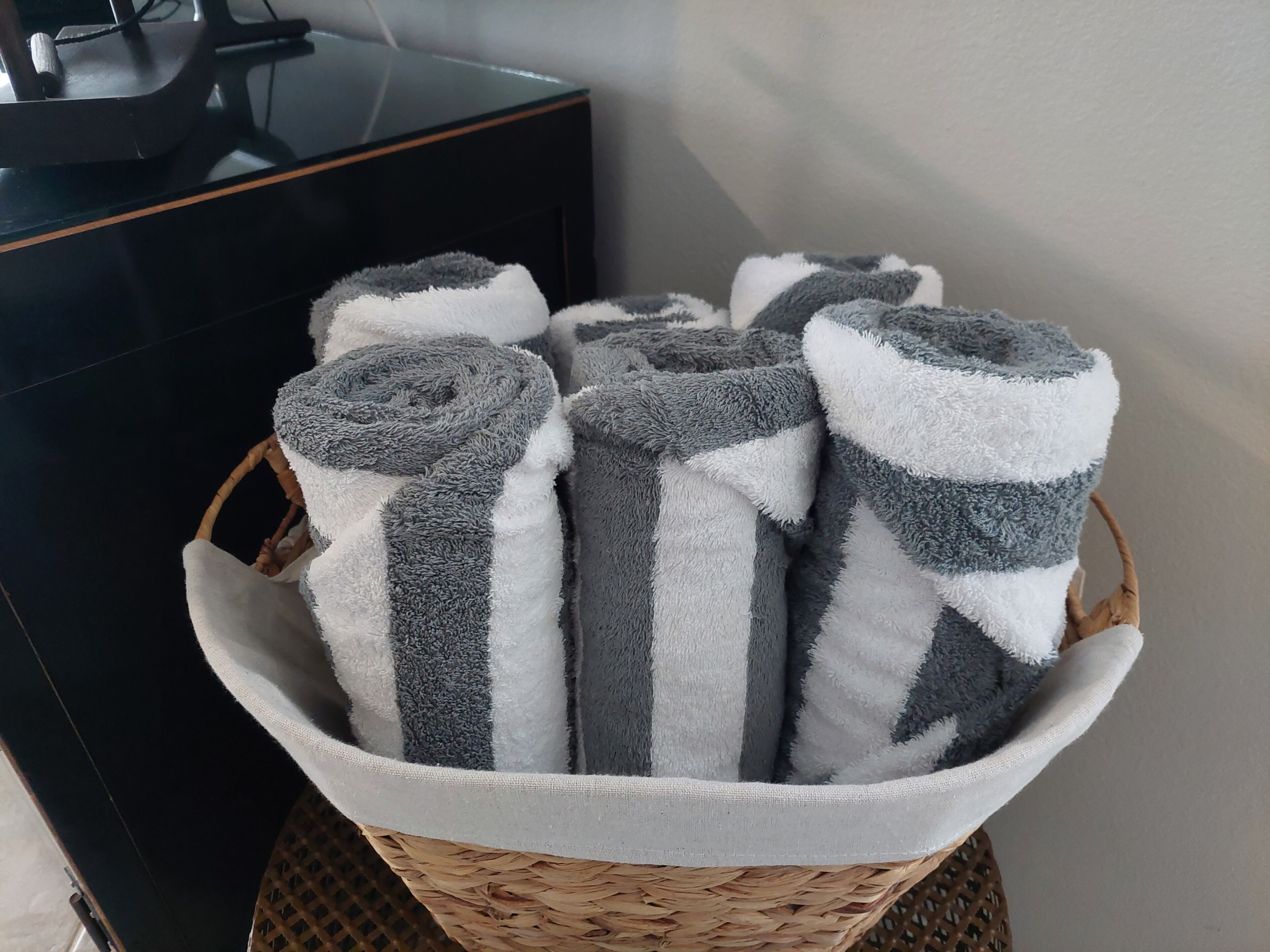 Ein Korb mit aufgerollten Handtüchern in einem Hotelzimmer.