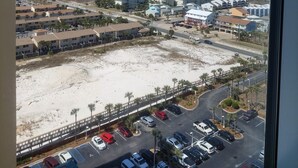 A coastal view with a parking lot, buildings, and a beach. - Stunning Beach Views of Gulf-14th Floor-Dog friendly-See the longest pier in FL! (Navarre)