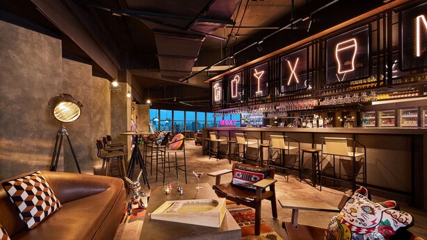 A bar area with a neon sign, bar stools, and a view of the city. - Moxy Shanghai Xuhui (Shanghai)
