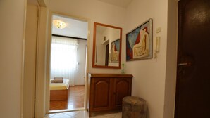 Une chambre d’hôtel avec un meuble en bois, un miroir et un tableau accroché au mur.