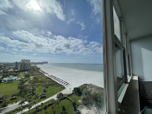 A view of a beach with a hotel in the background.