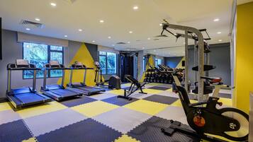 A gym with treadmills, elliptical machines, and weightlifting equipment.