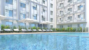 Una piscina al aire libre, tumbonas