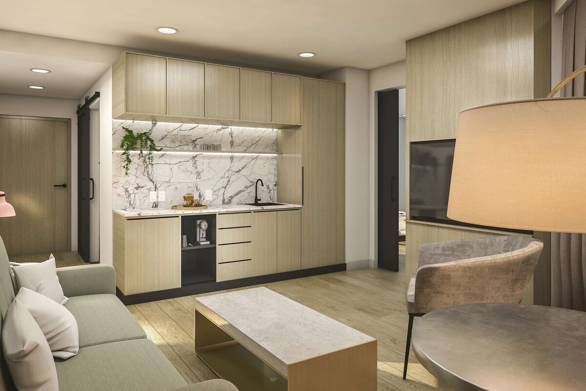 A modern kitchen with marble backsplash, wooden cabinets, and a built-in dishwasher.