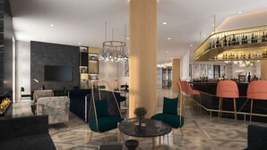 Un moderno vestíbulo de hotel con chimenea, zona de estar, bar y un pilar grande.