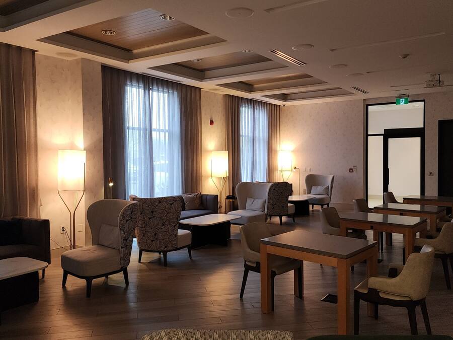 Eine Hotelhalle mit Sitzgelegenheiten, Tischen und einem großen Spiegel.