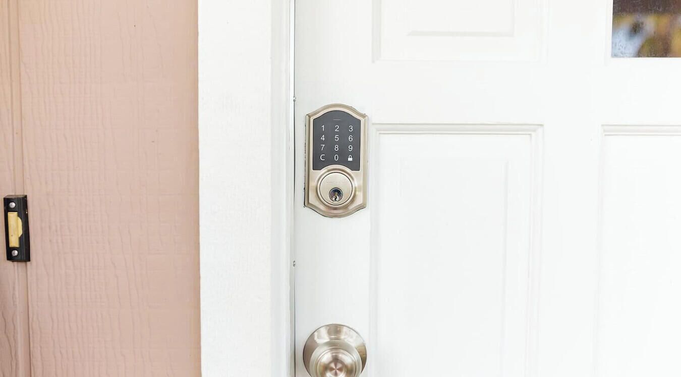 Une porte blanche dotée d’un clavier numérique et d’un trou de serrure.