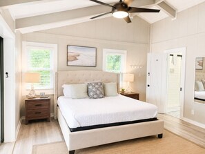 A bedroom with a bed, bedside tables, a ceiling fan, and two windows. - Sweeping Lake Views • Fire Pit • Hot Tub • Pets OK (Mooresville)
