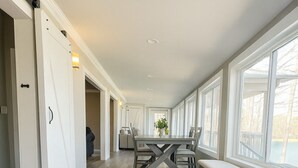 Una habitación amplia con un gran ventanal, una mesa de comedor con sillas y un banco.