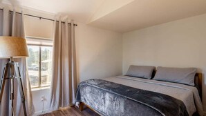 A bedroom with a bed, curtains, a lamp, and a window. - Perfect, fully furnished 1-bed condo  (Black Canyon City)