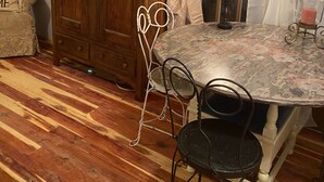 A room with a wooden wardrobe, a round table with chairs, and a window with curtains. - Country Cottage on the farm, peaceful, stars and fireflies! Sleeps 4! (Edmonton)