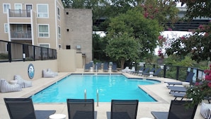 A swimming pool with lounge chairs and a sign indicating no diving. - City Condo with Outdoor Pool Near Broadway (Nashville)