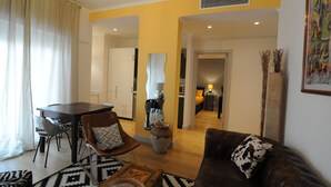 Uma sala de estar moderna com um sofá de couro marrom, uma mesa de jantar com cadeiras e uma parede com detalhes em amarelo.