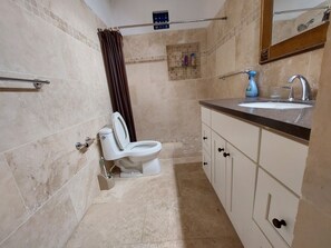 A bathroom with a toilet, sink, and cabinet.