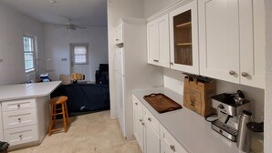 A compact kitchen with white cabinets, a countertop, a ceiling fan, and a refrigerator. - 1-bed House Sleeps 2 With Parking (Sandys Parish)