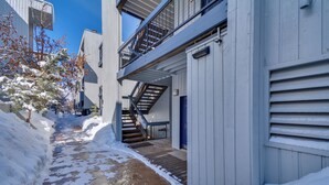 A narrow snow-covered pathway between buildings with a wooden staircase leading to a door. - Private Riverside Ski Retreat  2/2 condo close to Beaver Creek and Vail (Avon)