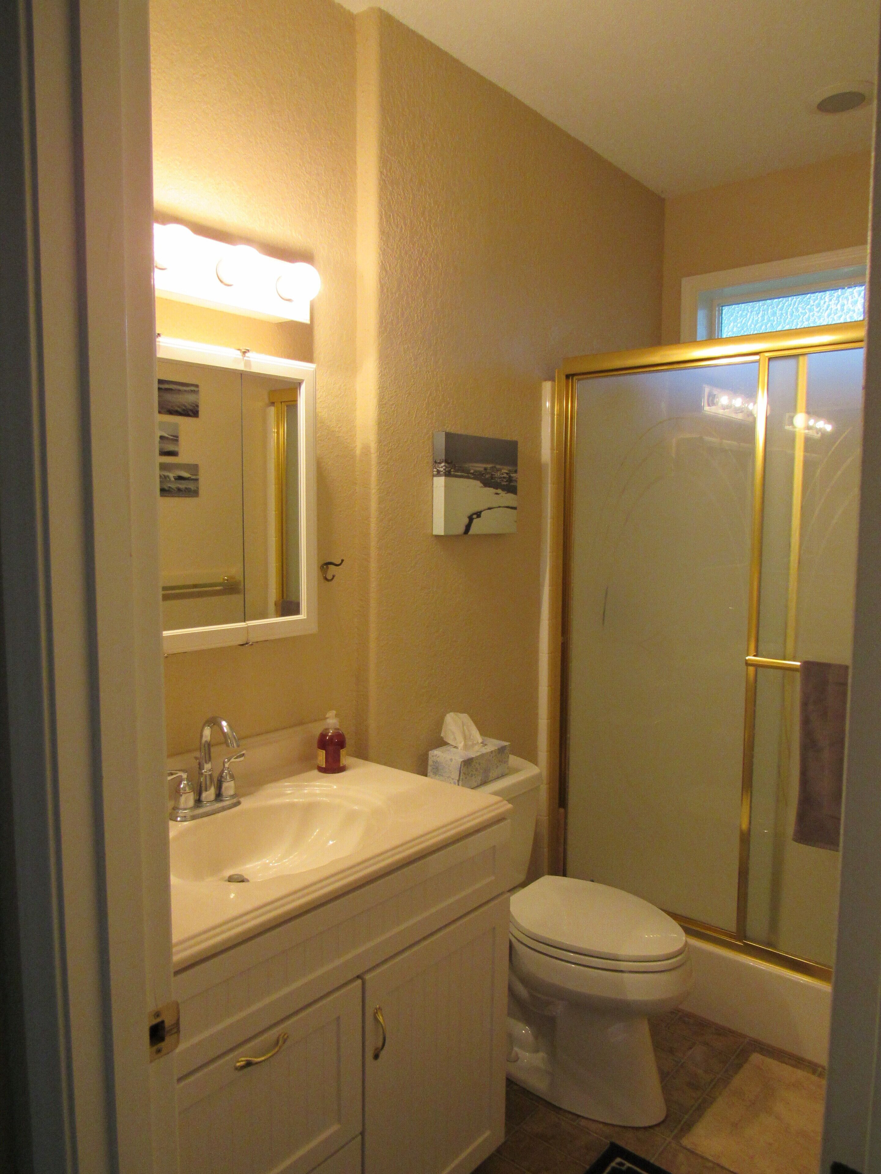 Une salle de bain avec un lavabo, un miroir et des toilettes.