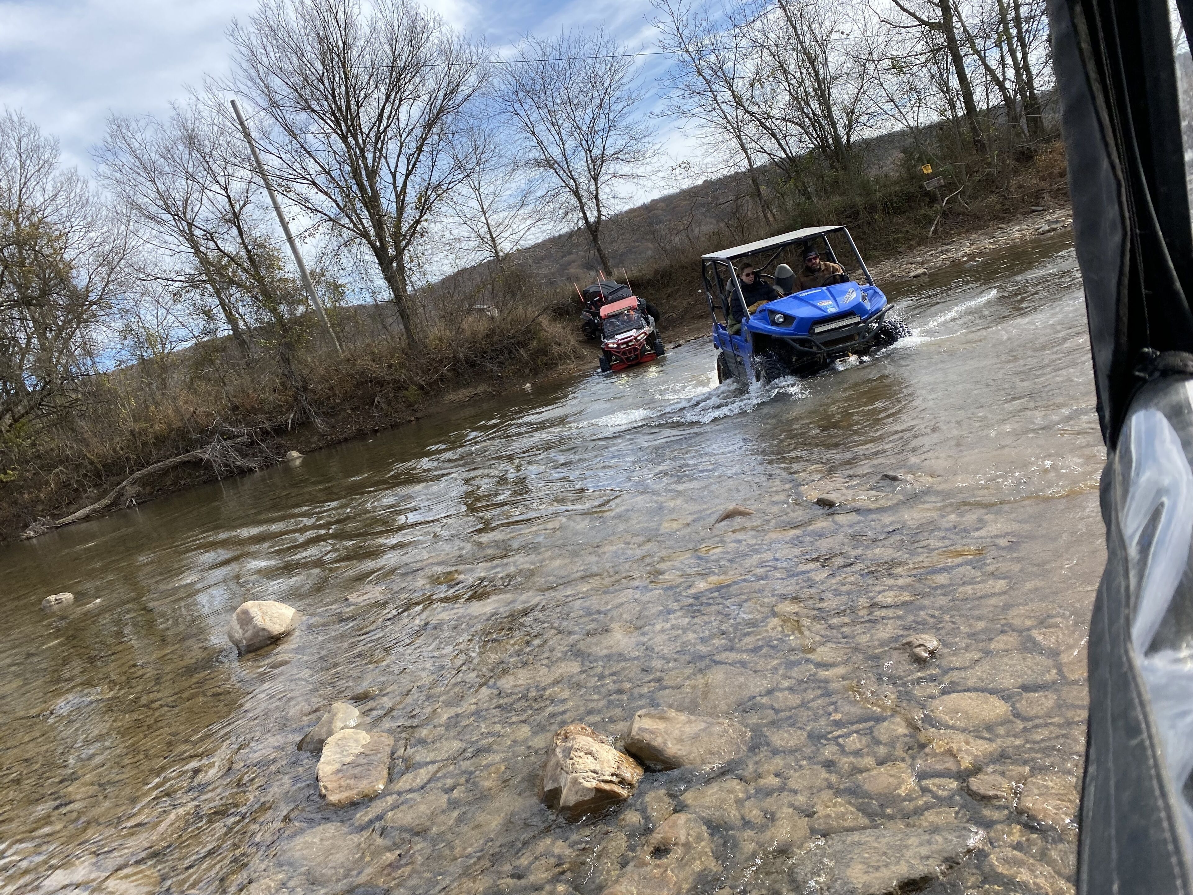 A river with a vehicle crossing it.