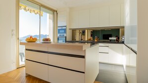 A modern kitchen with a large island, built-in appliances, and a view of the outdoors. - 3-Br Apartment, Sea View, by the Beaches (Cannes)