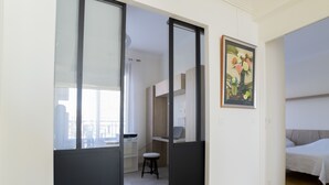 An interior view of a modern apartment with a kitchen area, a dining space, and a bedroom. - 3-Br Apartment, Sea View, by the Beaches (Cannes)