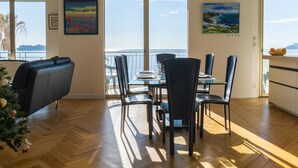 A dining area with a view of the sea, a Christmas tree, and artwork on the walls. - 3-Br Apartment, Sea View, by the Beaches (Cannes)