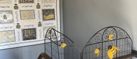 A staircase with a metal railing and a wall decorated with bee-themed wall art.