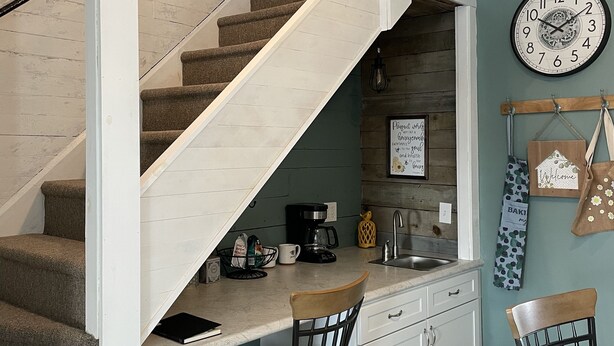 Una cocina con una escalera que sube a un altillo.