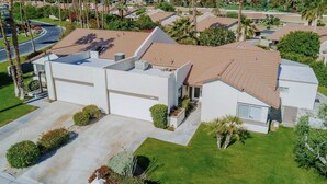 A modern two-story house with a flat roof, a garage, and a well-maintained lawn. - Classic Avondale  Private  Country Club ~ Gated community front gate security (Palm Desert)