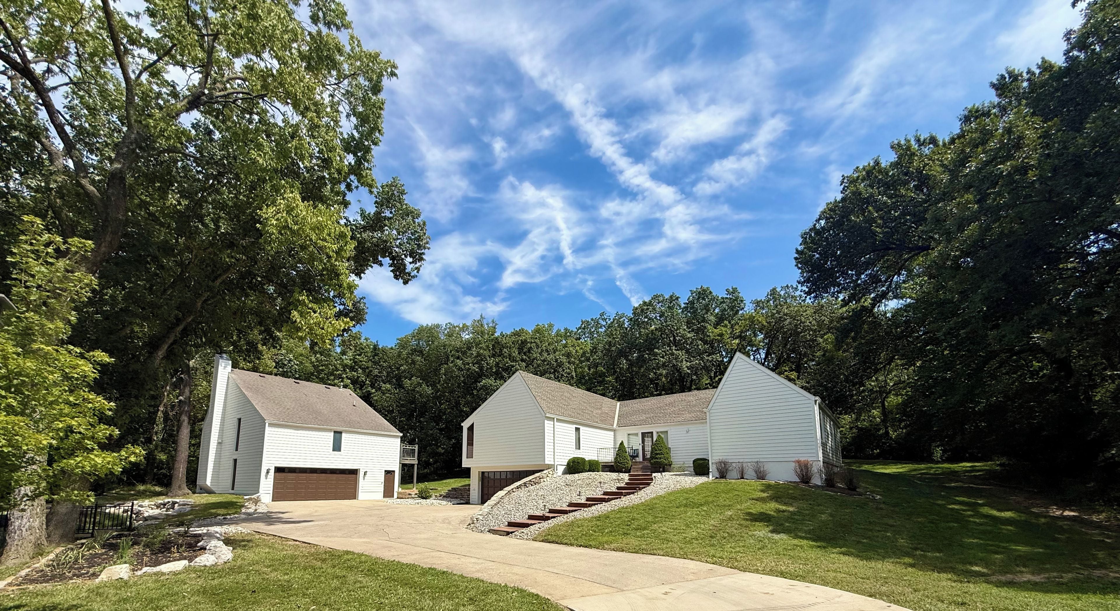A residential property with a two-car garage, a front lawn, and a driveway leading to the entrance.