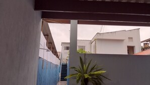 Un estrecho callejón flanqueado por una pared azul y otra blanca, que conduce a una escalera.