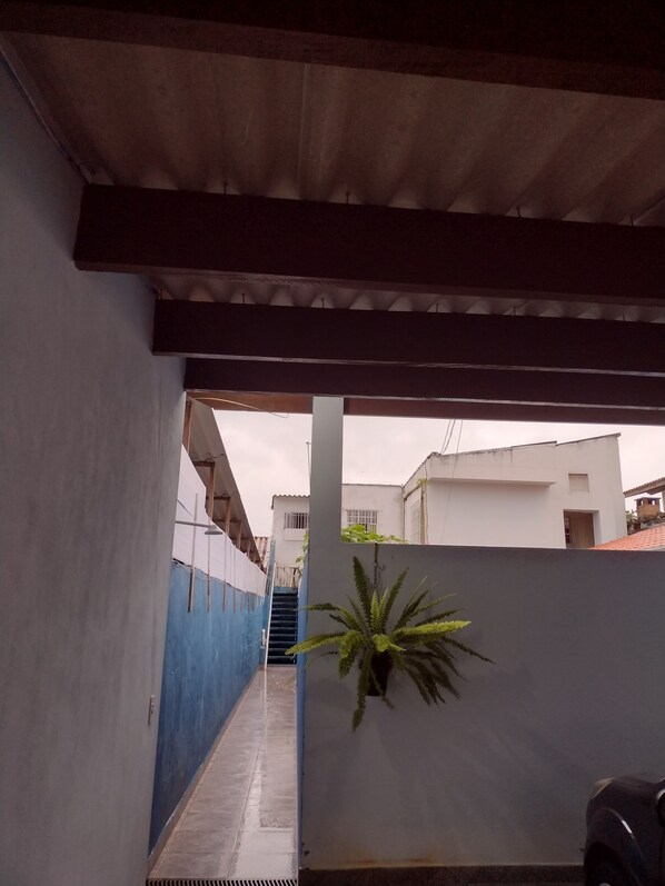 A narrow alleyway with a blue wall on one side and a white wall on the other, leading to a staircase.