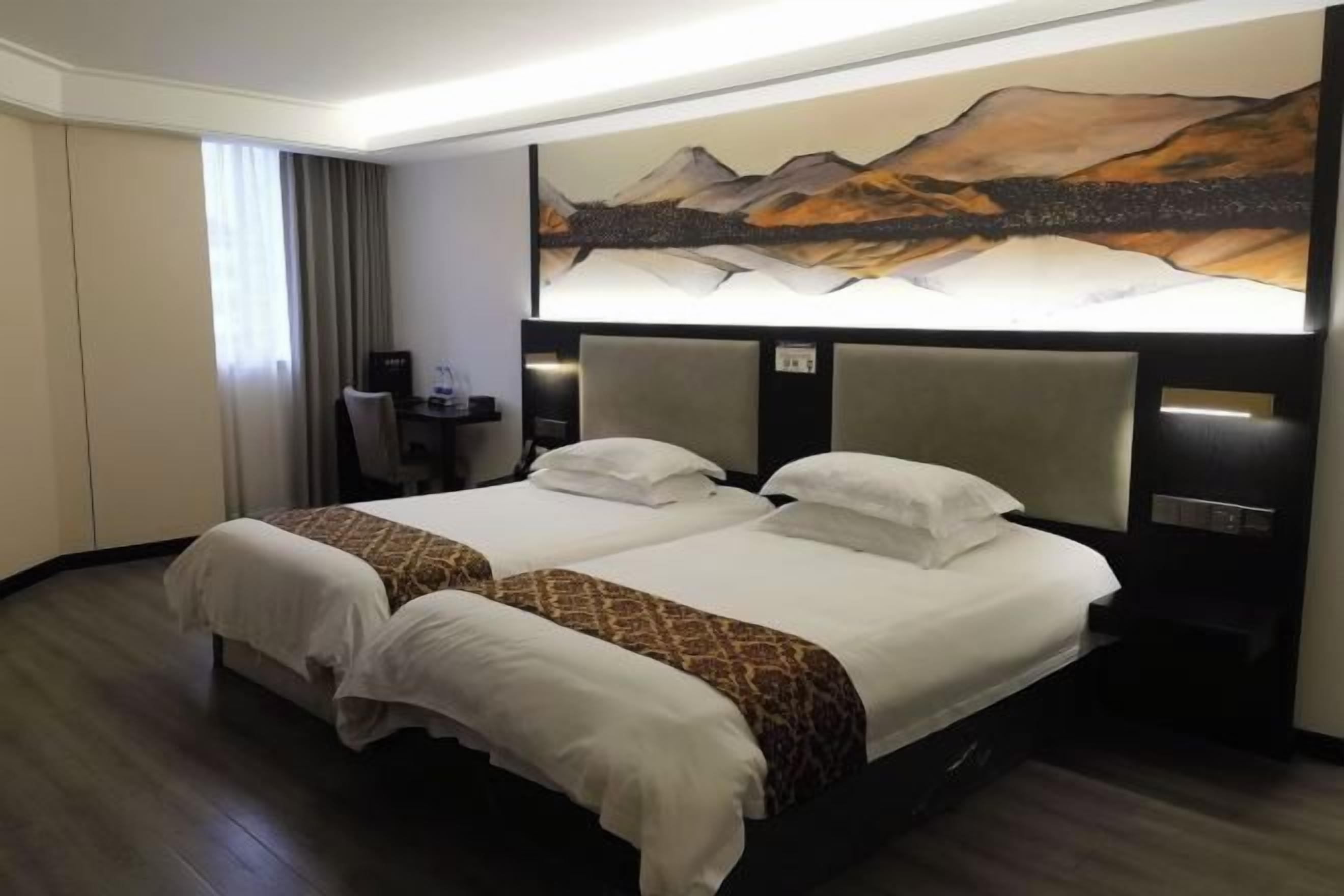 Una cama doble con cabecera, un escritorio y un cuadro en la pared.